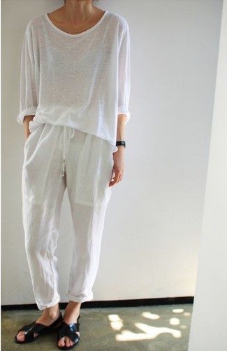 Модный лук: белая футболка с длинным рукавом, белые пижамные штаны, черные кожаные сандалии на плоской подошве