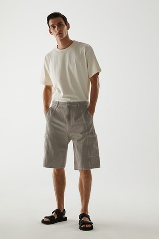 С чем носить сандалии мужчине: Белая футболка с круглым вырезом и серые джинсовые шорты — неотъемлемые предметы в гардеробе джентльменов с чувством стиля. Сандалии позволят сделать образ менее формальным.
