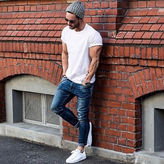 Какие зауженные джинсы носить с бело-черными низкими кедами мужчине лето: Если в одежде ты ценишь комфорт и функциональность, белая футболка с круглым вырезом и зауженные джинсы — превосходный выбор для модного мужского лука на каждый день. Любители экспериментировать могут закончить образ бело-черными низкими кедами, тем самым добавив в него чуточку изысканности. В теплый июльский день в такой одежде ты сможешь спастись от изнуряющего зноя.