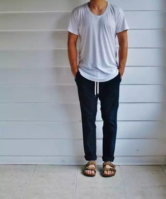 С чем носить бежевые замшевые сандалии в 30 лет мужчине лето: Белая футболка с круглым вырезом и темно-синие брюки чинос будет превосходной идеей для легкого повседневного лука. Любишь экспериментировать? Тогда дополни лук бежевыми замшевыми сандалиями. Пережить изнурительную летнюю жару несомненно легче, когда на тебе такое сочетание одежды.