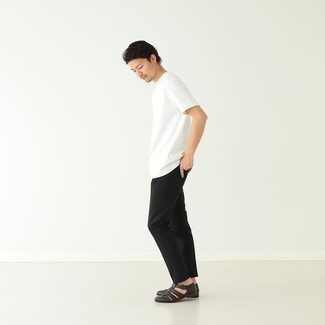 Как носить черные брюки чинос с темно-коричневыми кожаными сандалиями: Белая футболка с круглым вырезом и черные брюки чинос помогут составить гармоничный и стильный лук. Ты можешь легко приспособить такой образ к повседневным нуждам, закончив его темно-коричневыми кожаными сандалиями.