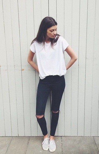 Модный лук: белая футболка с круглым вырезом, черные рваные джинсы скинни, серые низкие кеды из плотной ткани
