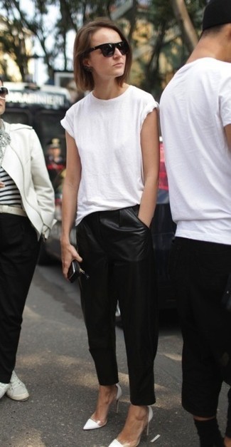 С чем носить черные кожаные узкие брюки в 30 лет: Белая футболка с круглым вырезом и черные кожаные узкие брюки — идеальный вариант, если ты ищешь простой, но в то же время модный лук. Белые кожаные туфли становятся отличным дополнением к твоему ансамблю.