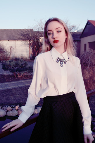 Модный лук: белая шифоновая классическая рубашка, черная стеганая короткая юбка-солнце, серебряное колье
