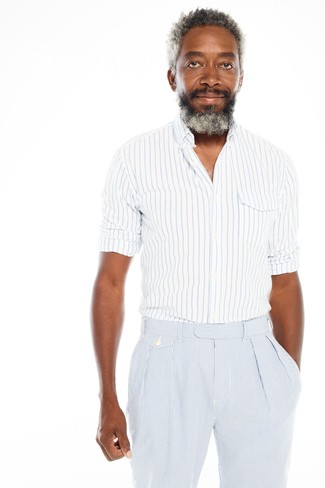 С чем носить голубые классические брюки за 40 лет мужчине в стиле смарт-кэжуал: Сочетание бело-синей рубашки с длинным рукавом в вертикальную полоску и голубых классических брюк может стать превосходным ансамблем для офиса.