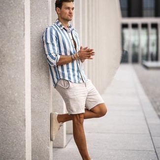 С чем носить бежевые льняные шорты в 20 лет мужчине в стиле кэжуал: Если ты любишь выглядеть по моде, и при этом чувствовать себя комфортно и нескованно, опробируй это сочетание бело-синей рубашки с коротким рукавом в вертикальную полоску и бежевых льняных шорт. В этот лук очень просто интегрировать бежевые низкие кеды из плотной ткани.