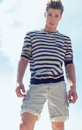 С чем носить бежевые шорты мужчине в теплую погоду: Если ты ценишь удобство и функциональность, бело-темно-синяя футболка с длинным рукавом в горизонтальную полоску и бежевые шорты — замечательный вариант для стильного повседневного мужского образа.