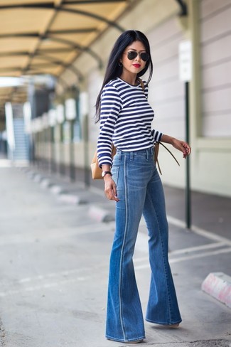 С чем носить джинсы-клеш осень: Бело-темно-синяя футболка с длинным рукавом в горизонтальную полоску и джинсы-клеш — необходимые вещи в арсенале девушек с чувством стиля. Когда ты одета стильно, справиться с хмурым осенним настроением определенно легче.
