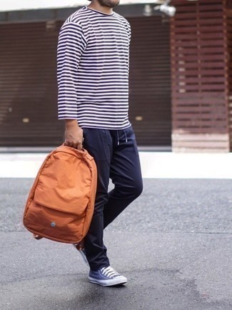 С чем носить оранжевую сумку в 30 лет мужчине лето в стиле кэжуал: Лук из бело-темно-синей футболки с длинным рукавом в горизонтальную полоску и оранжевой сумки - самый простой из возможных луков для активного выходного дня. Хочешь сделать образ немного элегантнее? Тогда в качестве обуви к этому образу, выбери темно-сине-белые низкие кеды из плотной ткани. В таком сочетании будет очень комфортно, когда на улице пекло.