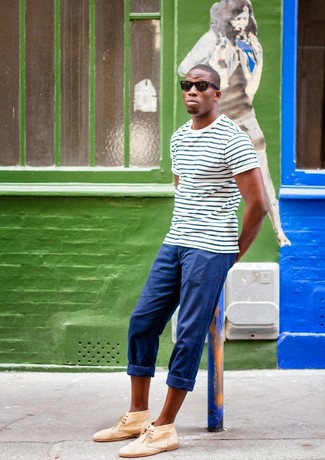 Модный лук: бело-темно-синяя футболка с круглым вырезом в горизонтальную полоску, синие брюки чинос, светло-коричневые замшевые ботинки дезерты, черные солнцезащитные очки