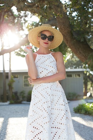 С чем носить шляпу женщине в жару в стиле смарт-кэжуал: Рекомендуем взять на заметку это функциональное сочетание белого платья-миди с люверсами и шляпы.