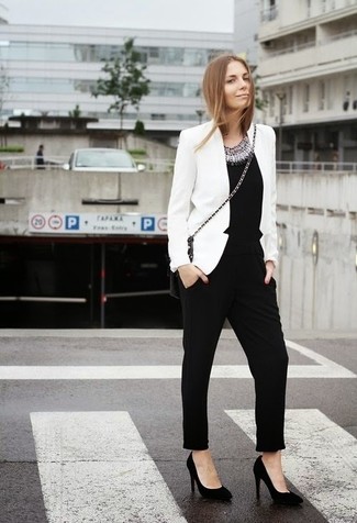 Модный лук: белый пиджак, черный комбинезон с украшением, черные замшевые туфли, черная кожаная сумка через плечо