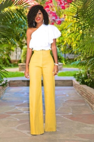 С чем носить желтые широкие брюки лето: Комбо из белого топа с открытыми плечами с рюшами и желтых широких брюк — великолепный вариант для создания наряда в стиле business casual. Уверены, это великолепная идея для жаркой летней погоды.