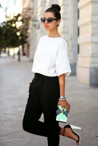 Модный лук: белая блуза с коротким рукавом, черные брюки-галифе, бело-черные кожаные босоножки на каблуке, мятный кожаный клатч с геометрическим рисунком