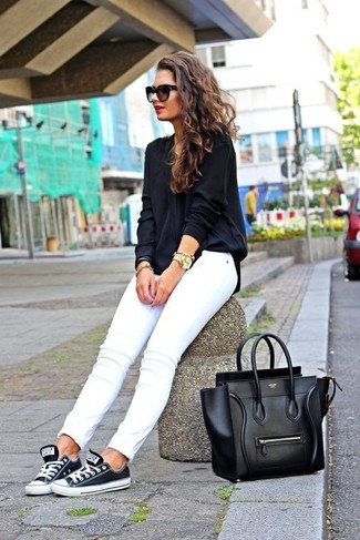 Как носить черную блузку с длинным рукавом с черно-белыми низкими кедами в жару в стиле смарт-кэжуал: Если ты приписываешь себя к той редкой категории женщин, неплохо ориентирующихся в трендах, тебе подойдет сочетание черной блузки с длинным рукавом и белых джинсов скинни. Чтобы образ не получился слишком зализанным, можно надеть черно-белые низкие кеды.