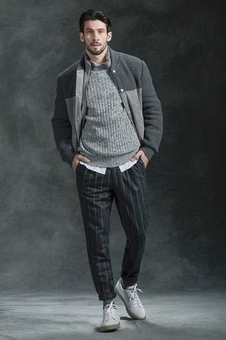 Как носить вязаный свитер с низкими кедами в 30 лет мужчине осень в стиле смарт-кэжуал: Тандем вязаного свитера и темно-серых шерстяных классических брюк в вертикальную полоску смотрится очень выгодно, согласен? Чтобы образ не получился слишком претенциозным, можешь закончить его низкими кедами. Когда ты одет со вкусом, весь день проходит на позитиве, даже если на улице по-осеннему хмуро и уныло.