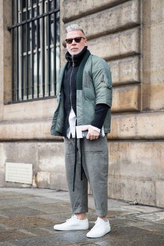 С чем носить бомбер за 50 лет мужчине осень в стиле смарт-кэжуал: Бомбер в сочетании с серыми шерстяными брюками чинос позволит подчеркнуть твою индивидуальность и выгодно выделиться из общей массы. Что касается обуви, можешь отдать предпочтение комфорту и надеть белые кожаные низкие кеды. Такой образ несомненно полюбится тебе осенью.