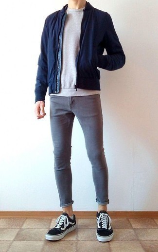 С чем носить темно-синий бомбер в 20 лет мужчине: Сочетание темно-синего бомбера и серых зауженных джинсов — великолепный вариант для создания мужского лука в стиле смарт-кэжуал. В сочетании с этим ансамблем идеально будут выглядеть черно-белые низкие кеды из плотной ткани.