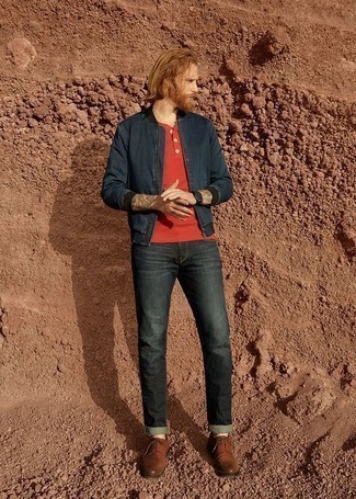 Модный лук: темно-синий джинсовый бомбер, красная футболка на пуговицах, темно-серые джинсы, коричневые кожаные туфли дерби