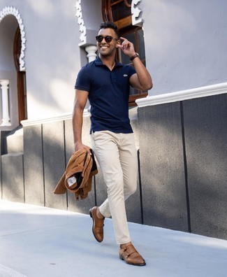 Как носить светло-коричневые брюки чинос с синей футболкой-поло в теплую погоду: Сочетание синей футболки-поло и светло-коричневых брюк чинос позволит подчеркнуть твою индивидуальность и выигрышно выделиться из общей массы. Коричневые кожаные монки с двумя ремешками добавят ансамблю стильной строгости.