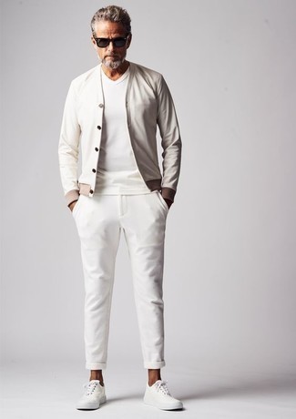 С чем носить бело-черные брюки чинос за 40 лет в теплую погоду: Белый бомбер и бело-черные брюки чинос — обязательные составляющие в гардеробе мужчин с превосходным чувством стиля. Если сочетание несочетаемого импонирует тебе не меньше, чем проверенная классика, дополни этот лук белыми низкими кедами из плотной ткани.