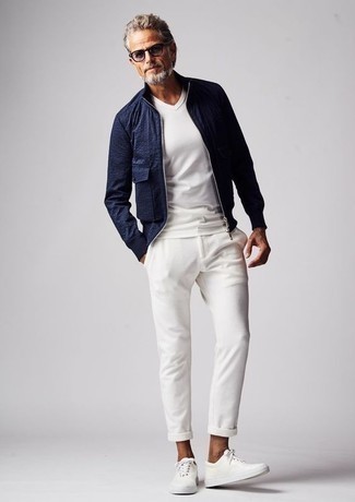 Модный лук: темно-синий бомбер, белая футболка с v-образным вырезом, белые брюки чинос, белые кожаные низкие кеды