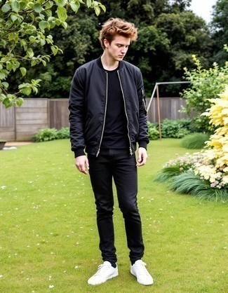 Модный мужской лук: черный бомбер, черная футболка с круглым вырезом, черные джинсы, белые низкие кеды из плотной ткани