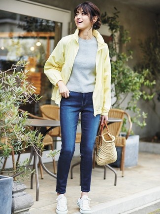 Модный лук: желтая ветровка, серая кофта с коротким рукавом, темно-синие джинсы скинни, белые низкие кеды из плотной ткани