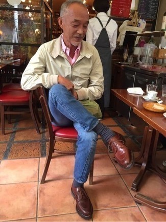 Как носить коричневые кожаные туфли дерби с темно-синими джинсами: Бежевая ветровка и темно-синие джинсы отлично впишутся в мужской лук в непринужденном стиле. Разнообразить лук и добавить в него немного классики помогут коричневые кожаные туфли дерби.