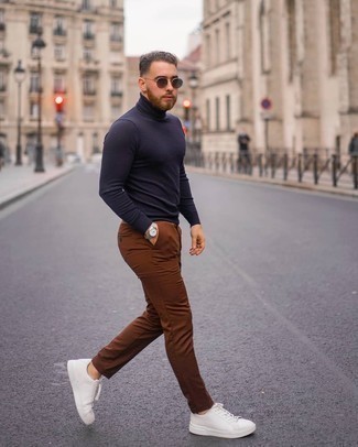 С чем носить темно-синюю водолазку мужчине в стиле кэжуал: Дуэт темно-синей водолазки и коричневых брюк чинос как нельзя лучше подчеркнет твой личный стиль. Если ты не боишься рисковать, на ноги можешь надеть белые кожаные низкие кеды.