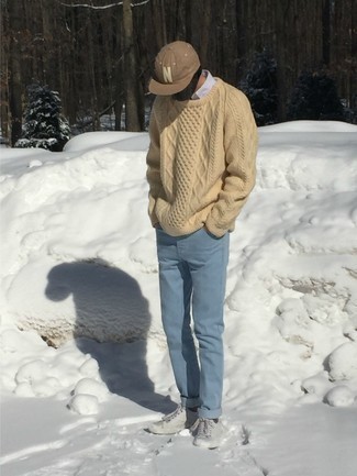 Модный лук: бежевый вязаный свитер, белая рубашка с длинным рукавом, голубые джинсы, серые низкие кеды из плотной ткани