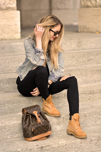 Модный лук: голубая джинсовая куртка, черные рваные джинсы скинни, светло-коричневые замшевые ботинки на шнуровке, темно-коричневый кожаный рюкзак с принтом
