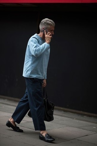 С чем носить черные кожаные лоферы с кисточками за 40 лет в стиле смарт-кэжуал: Комбо из голубой футболки с длинным рукавом и темно-синих брюк чинос продолжает импонировать джентльменам, которые всегда одеты стильно. Думаешь сделать образ немного строже? Тогда в качестве дополнения к этому ансамблю, стоит выбрать черные кожаные лоферы с кисточками.