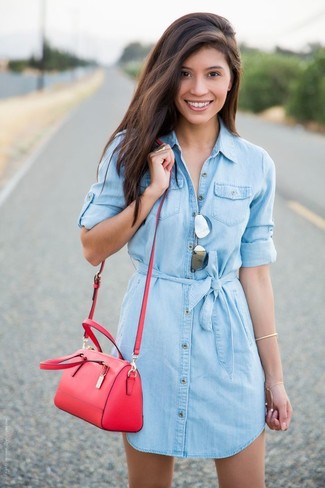 С чем носить красную кожаную сумку через плечо в жару: Голубое джинсовое платье-рубашка и красная кожаная сумка через плечо — идеальный наряд для активного выходного дня.