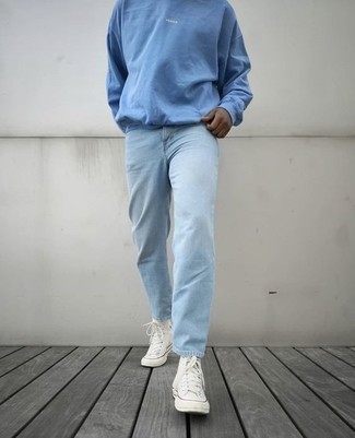 С чем носить голубые джинсы в 20 лет мужчине в теплую погоду: Голубой свитшот и голубые джинсы — обязательные вещи в арсенале стильного молодого человека. Любители смелых вариантов могут завершить ансамбль белыми высокими кедами из плотной ткани.