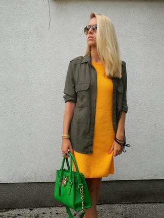 Модный лук: горчичное повседневное платье, темно-зеленая блуза на пуговицах, зеленая кожаная большая сумка, коричневые солнцезащитные очки