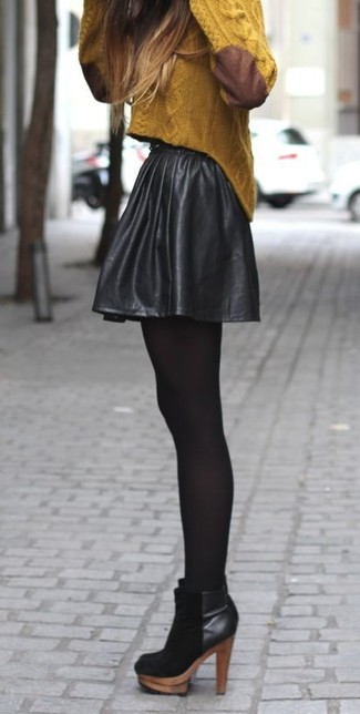 Модный лук: горчичный вязаный свитер, черная кожаная короткая юбка-солнце, черные замшевые ботильоны, черные колготки