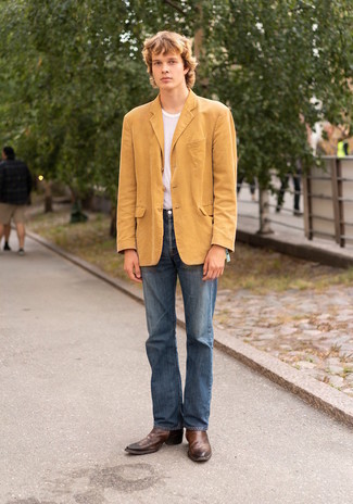 С чем носить желтый пиджак в 20 лет мужчине в теплую погоду: Желтый пиджак и синие джинсы помогут составить гармоничный модный ансамбль. Сбалансировать образ и добавить в него чуточку классики помогут коричневые кожаные ботинки челси.