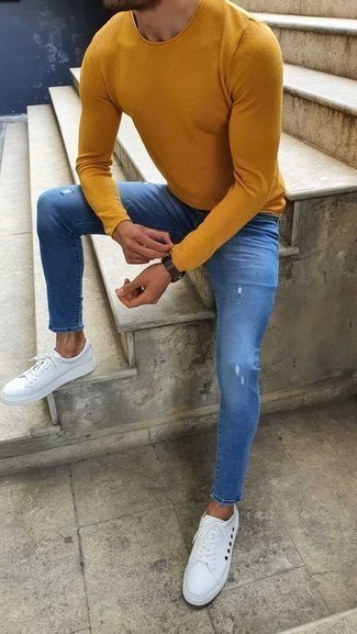 Как носить синие рваные джинсы с белыми низкими кедами мужчине: Горчичный свитер с круглым вырезом и синие рваные джинсы — стильный выбор молодых людей, которые всегда в движении. Хотел бы сделать лук немного строже? Тогда в качестве обуви к этому образу, выбери белые низкие кеды.