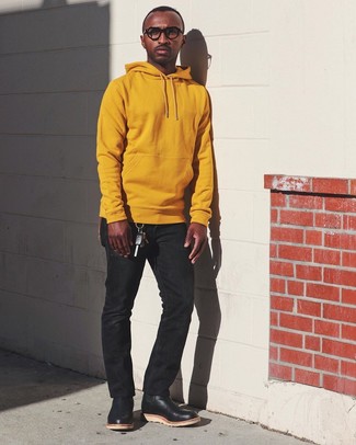 С чем носить желтый худи в 30 лет мужчине: Практичное сочетание желтого худи и черных джинсов поможет выразить твою индивидуальность и выгодно выделиться из общей массы. Если ты не боишься сочетать в своих луках разные стили, из обуви можешь надеть черные кожаные ботинки челси.