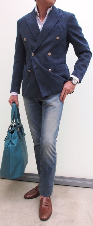 С чем носить темно-синий хлопковый двубортный пиджак мужчине: Темно-синий хлопковый двубортный пиджак в паре с синими джинсами — отличный пример вольного офисного стиля для молодых людей. Немного стильной строгости и классики луку добавит пара коричневых кожаных лоферов.