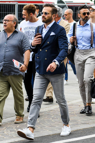 Как носить темно-серые джинсы с бело-черными кожаными низкими кедами в 30 лет мужчине в стиле смарт-кэжуал: Сочетание темно-синего двубортного пиджака в вертикальную полоску и темно-серых джинсов — идеальный офисный вариант для парней. Пара бело-черных кожаных низких кед добавит ансамблю расслабленности и беззаботства.