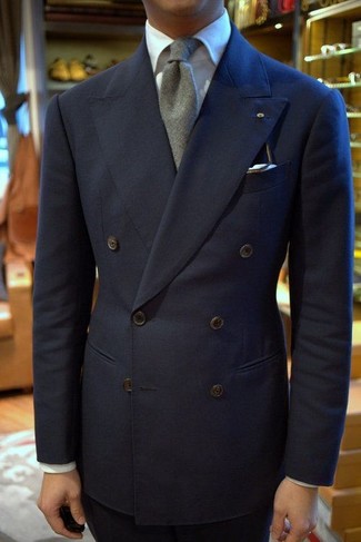 С чем носить серый шерстяной галстук в 30 лет мужчине в теплую погоду в деловом стиле: Темно-синий двубортный пиджак в сочетании с серым шерстяным галстуком — превосходный пример строгого мужского стиля.