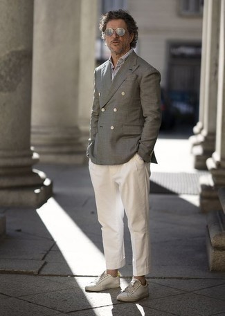С чем носить белые кожаные низкие кеды за 40 лет мужчине в теплую погоду: Серый двубортный пиджак в паре с белыми классическими брюками позволит создать модный классический образ. Создать модный контраст с остальными вещами из этого образа помогут белые кожаные низкие кеды.