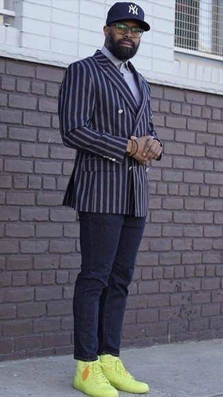 С чем носить золотые кеды за 40 лет мужчине в теплую погоду в стиле смарт-кэжуал: Темно-синий двубортный пиджак в вертикальную полоску и темно-синие джинсы — классное решение для встреч с дресс-кодом business casual. Такой образ легко приспособить к повседневным реалиям, если закончить его золотыми кедами.