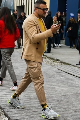 С чем носить светло-коричневый шерстяной двубортный пиджак мужчине в теплую погоду в стиле смарт-кэжуал: Светло-коричневый шерстяной двубортный пиджак и светло-коричневые брюки карго — замечательное решение для мероприятий с дресс-кодом business casual. Любители смелых сочетаний могут дополнить образ голубыми кроссовками.