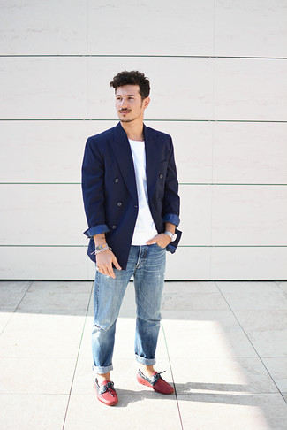 С чем носить темно-синий пиджак мужчине лето в стиле кэжуал: Темно-синий пиджак будет выглядеть отлично в сочетании с синими рваными джинсами. Любители свежих идей могут дополнить образ красными кожаными мокасинами, тем самым добавив в него толику изысканности. В знойный летний день в таком сочетании ты сможешь спастись от мучительного зноя.