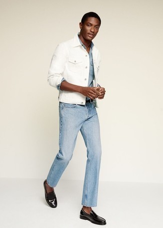 С чем носить голубые джинсы в 20 лет мужчине в теплую погоду: Тандем белой джинсовой куртки и голубых джинсов безусловно подчеркнет твой личный стиль. Хотел бы привнести в этот лук немного строгости? Тогда в качестве обуви к этому ансамблю, выбери черные кожаные лоферы.