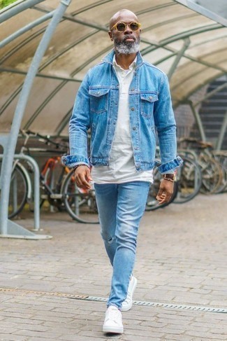 С чем носить низкие кеды за 50 лет мужчине в спортивном стиле: Голубая джинсовая куртка и голубые рваные джинсы — идеальный выбор для активного выходного дня. Очень неплохо здесь смотрятся низкие кеды.