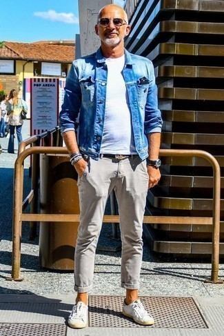 Как носить темно-синюю джинсовую куртку с серыми брюками чинос за 40 лет лето: Ансамбль из темно-синей джинсовой куртки и серых брюк чинос вдохновляет на проявление личного стиля. Такой образ легко адаптировать к повседневным нуждам, если закончить его белыми кожаными низкими кедами. Как видишь, это крайне удобное и несложное сочетание для летнего сезона.